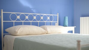 A bed with a white metal headboard, a blue vase, and a white radiator. - Cala Chiara B&B (Ortona)