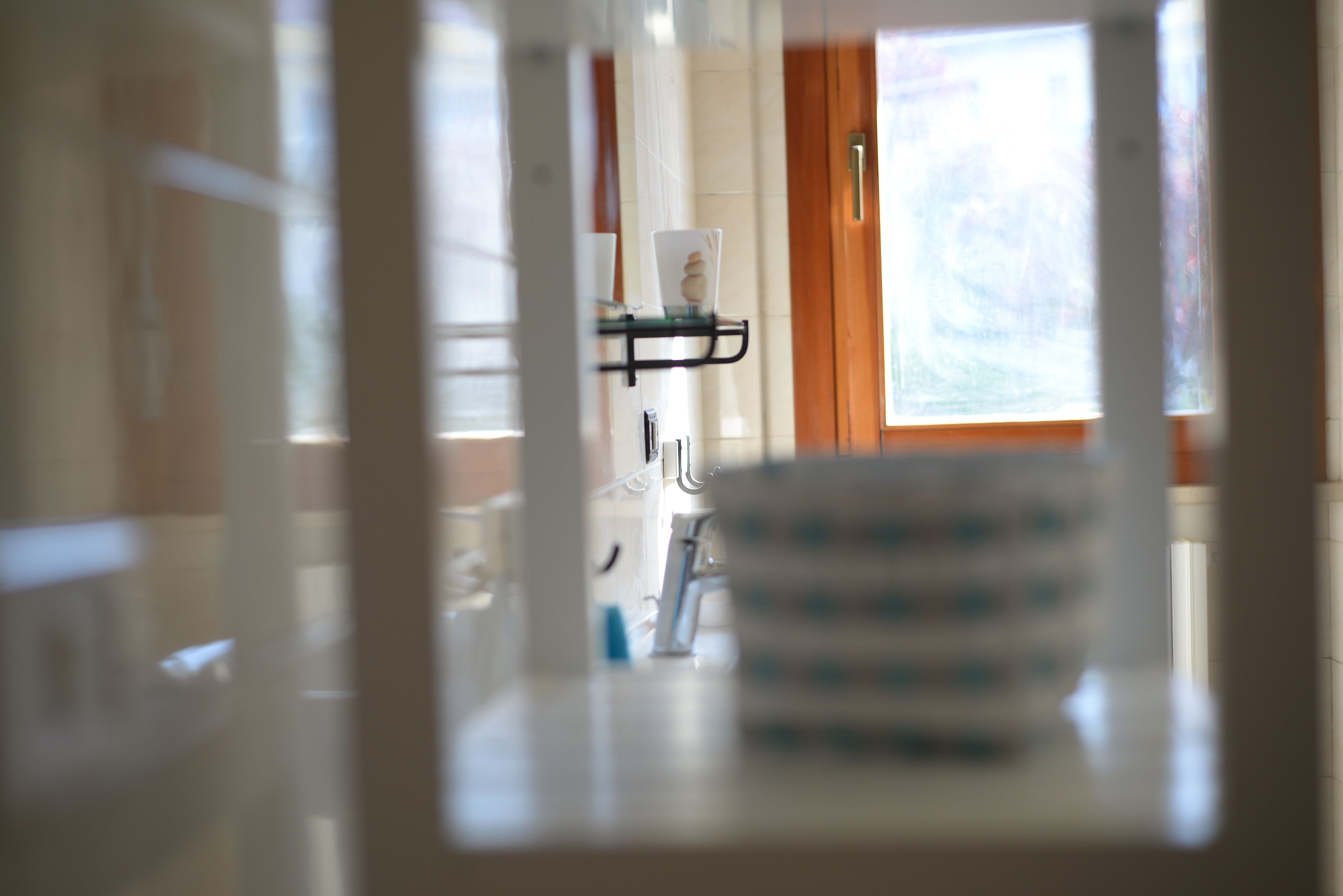 Ein Badezimmer mit einer Glasablage für Pflegeprodukte, einem Handtuchhalter und einem Fenster mit Aussicht.