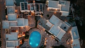 Oversigtsbillede af et resort med flere bygninger, en swimmingpool og udendørs siddeområder.
