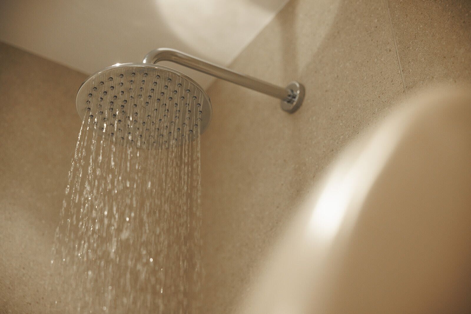 A showerhead with water flowing from it.