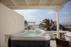 A hot tub in a covered outdoor area with a view of the sea and mountains. - Proteas Hotel & Suites (Naxos)