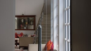 A staircase leading to a landing with a view of a living room. - Villa Raha (Colombo)