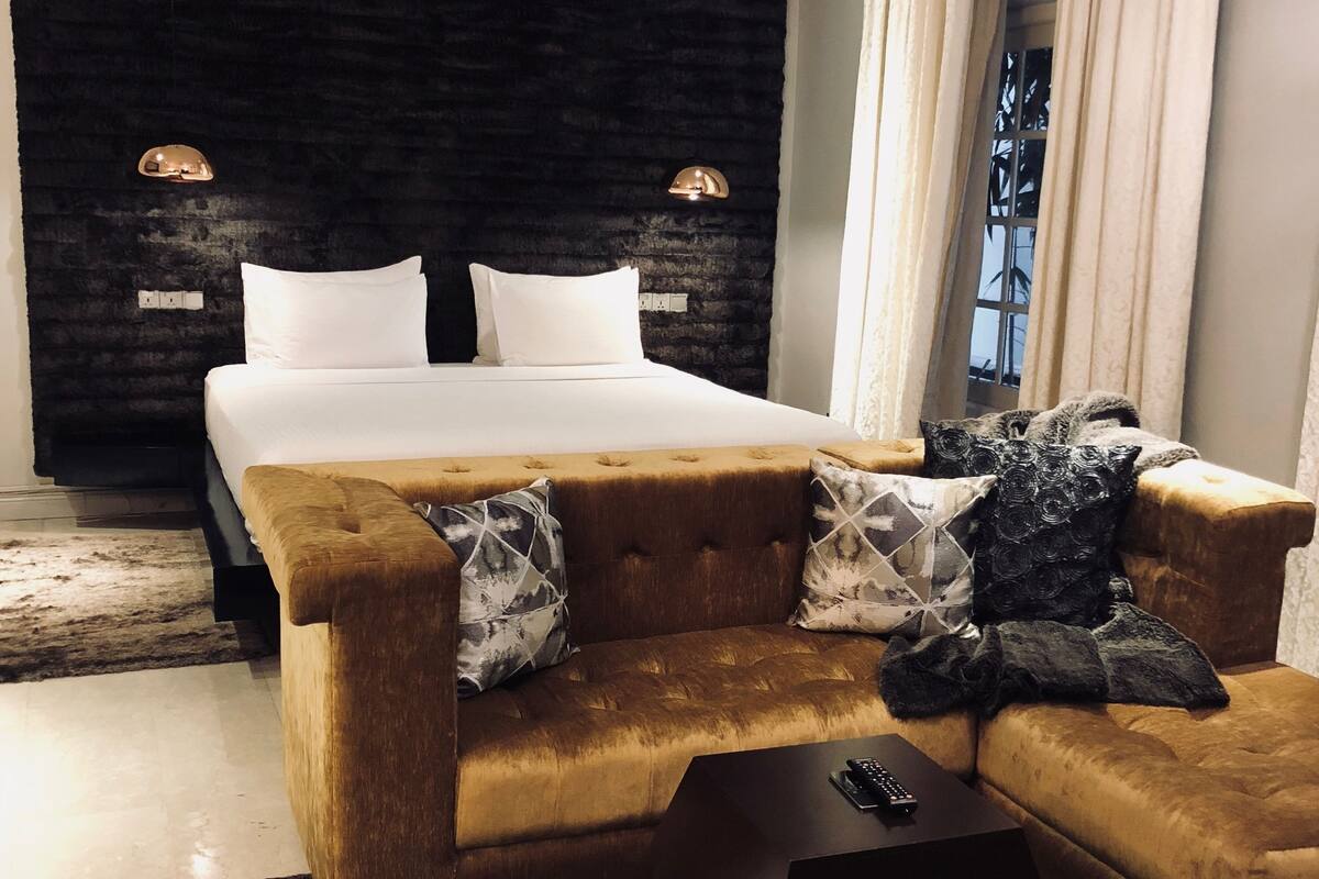 Une chambre moderne avec un grand lit, un canapé et une table basse.