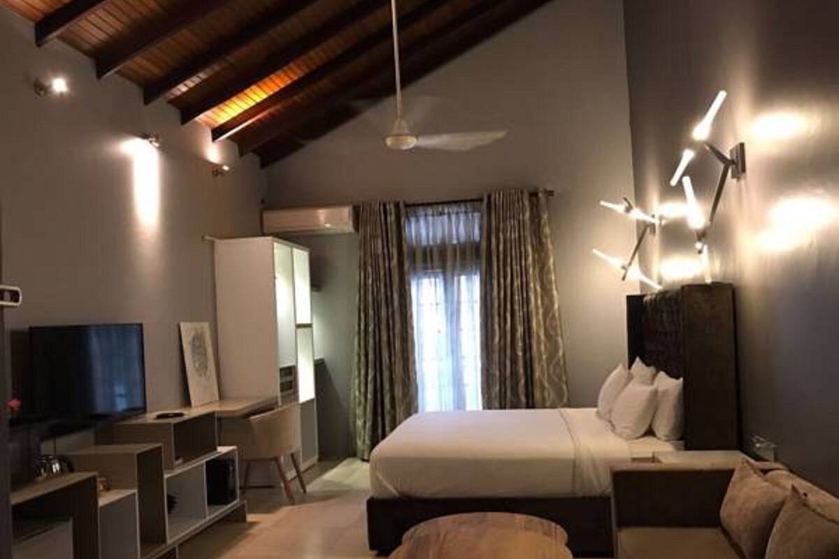 Une chambre à coucher moderne avec un lit, une télévision, un bureau et un canapé.