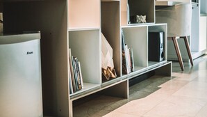 A modern living room with built-in shelving units, a flat-screen TV, and a minimalist design. - Villa Raha (Colombo)