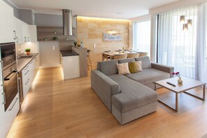 Apartamento Deluxe | Zona de estar | Televisión de pantalla plana de 50 pulgadas con canales por cable