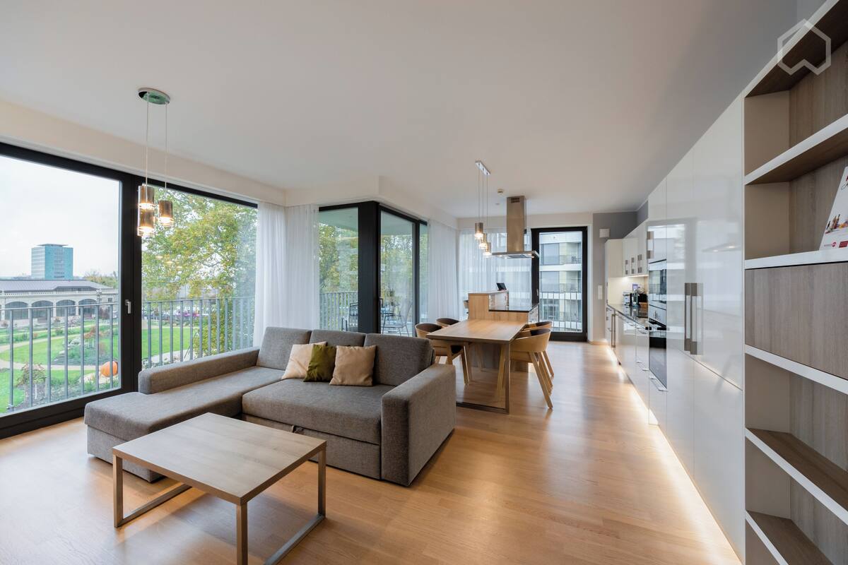 A modern living room with a sofa, coffee table, and dining area.