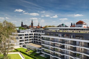 A multi-story building with a modern architectural design, featuring balconies and large windows.