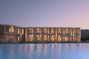 A hotel with a pool, multiple balconies, and outdoor seating. - Fata Morgana Studios & Apartments (Sfakia)