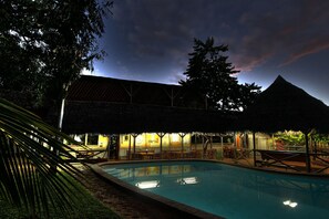 Una piscina al aire libre, sombrillas, sillones reclinables de piscina