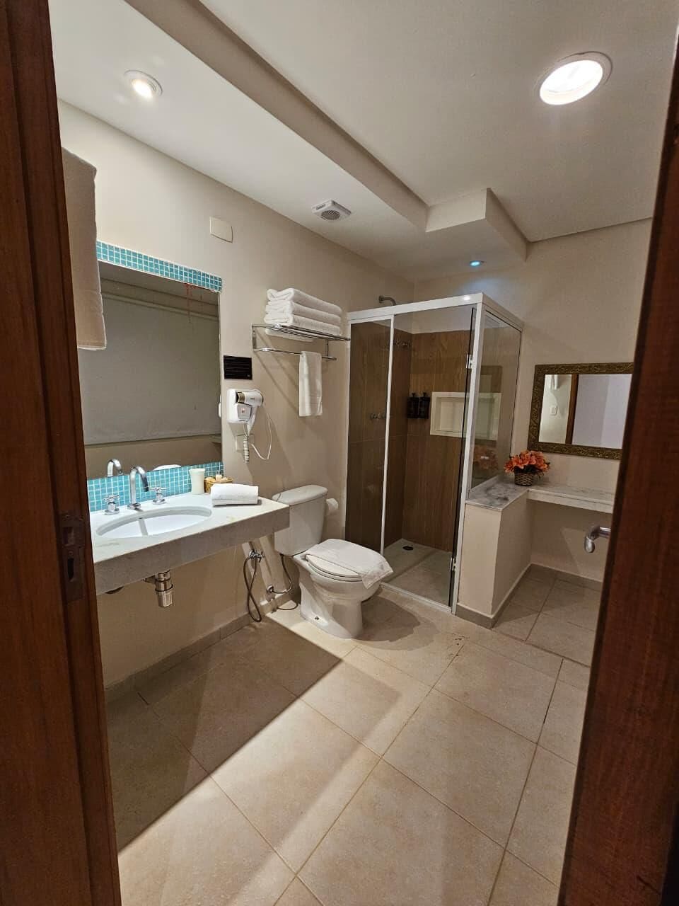 A modern bathroom with a shower, toilet, and sink.
