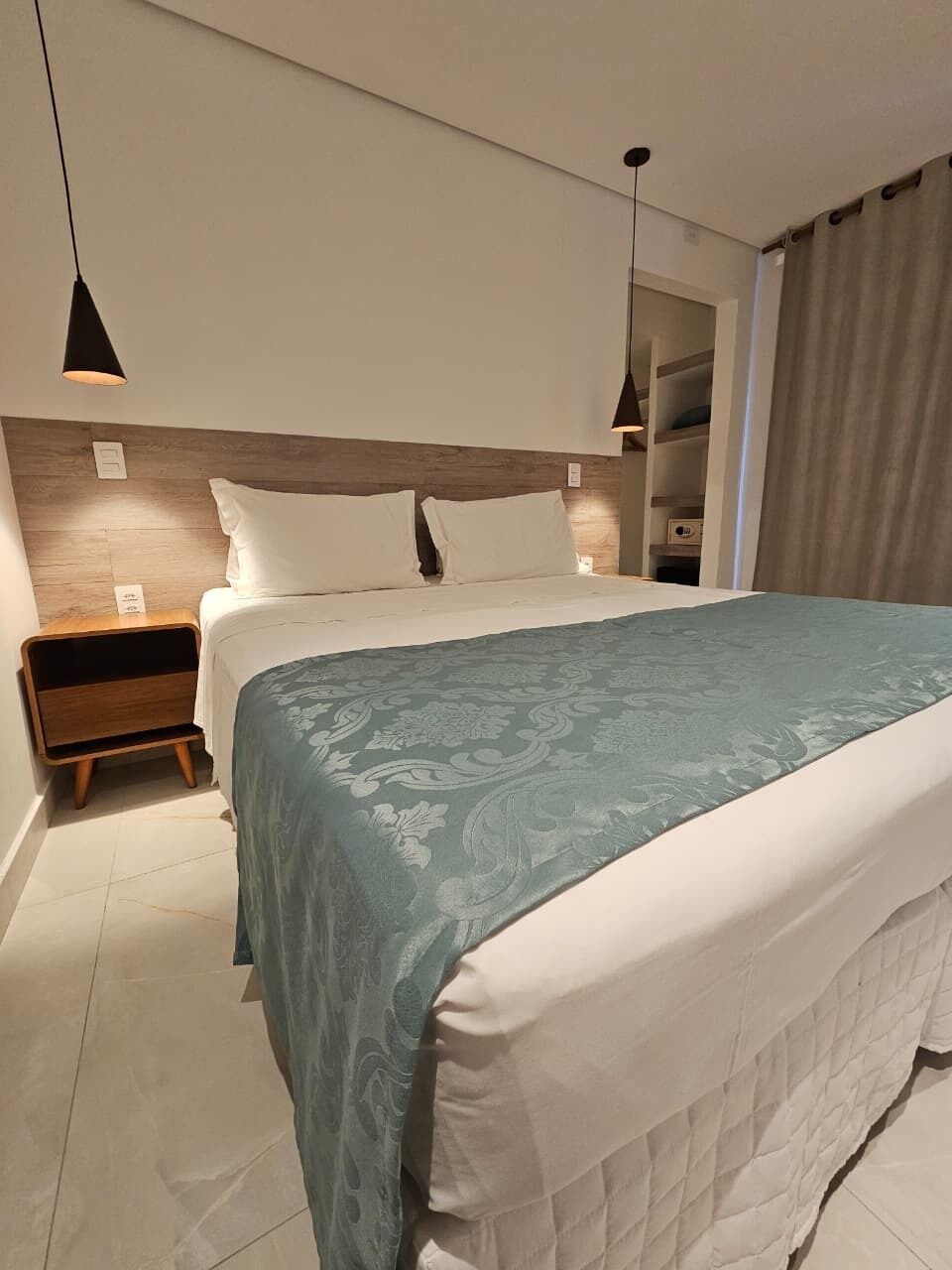 A modern bedroom with a large bed, bedside tables, and a headboard.