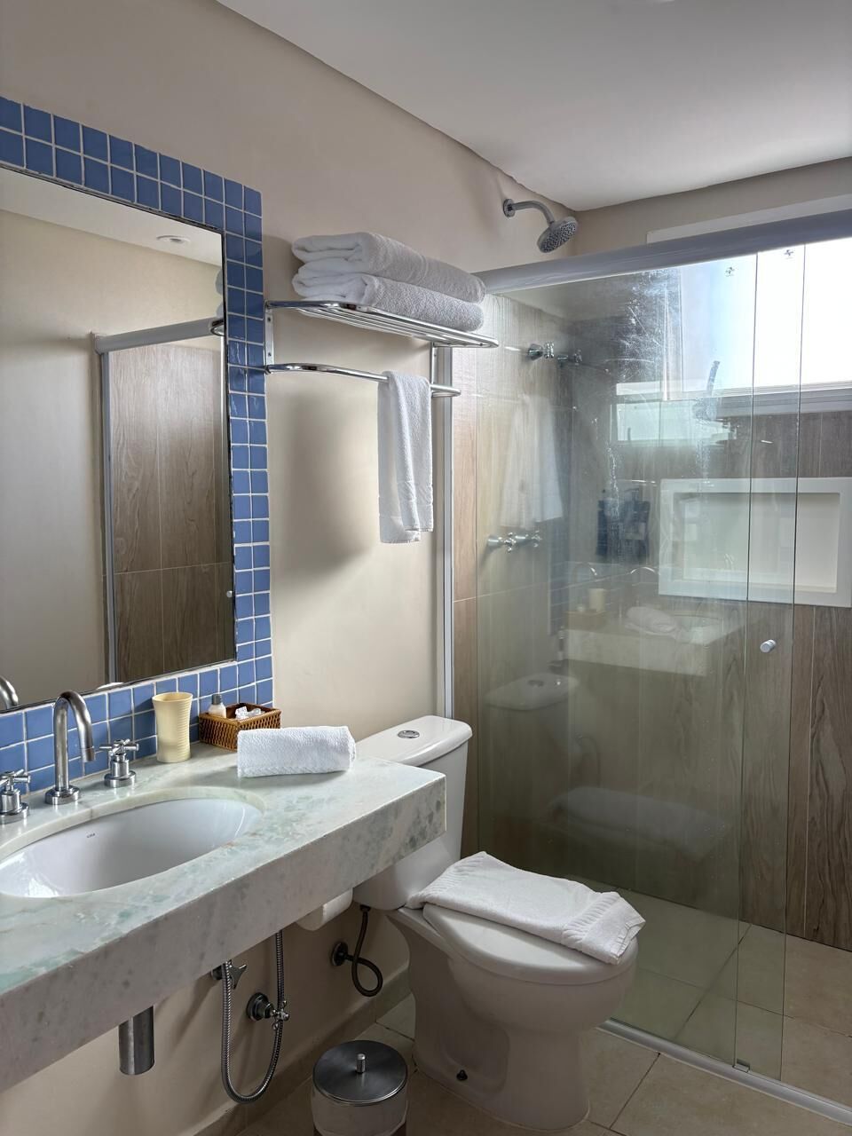 Une salle de bain équipée d’une douche, de toilettes, d’un lavabo et d’un miroir.