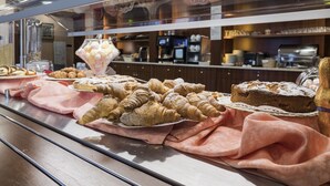 A bakery display with pastries and a coffee machine in the background. - Hotel Gardenia (Sirmione)