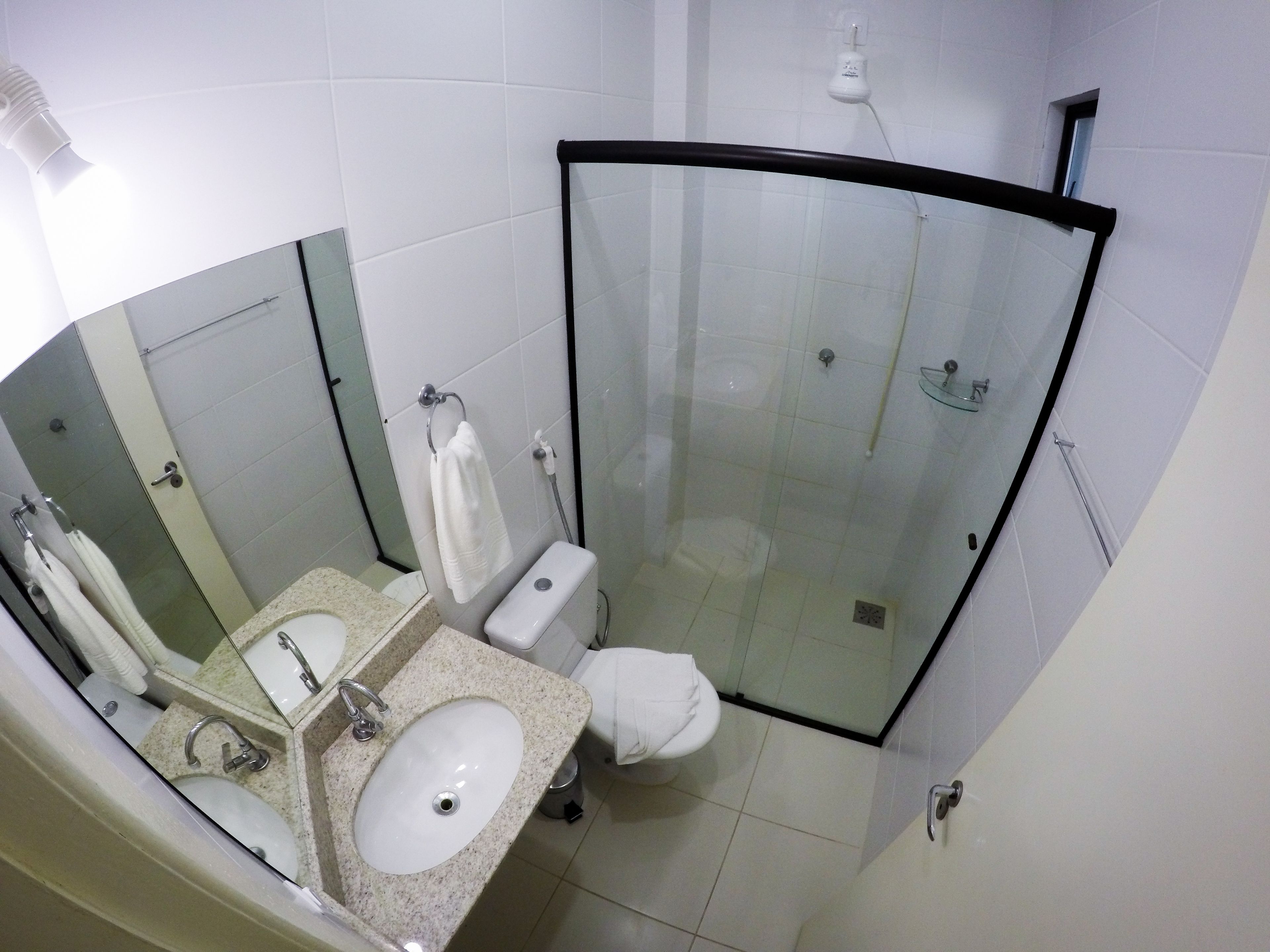Un bagno moderno con doccia vetrata, doppio lavabo e servizi igienici.
