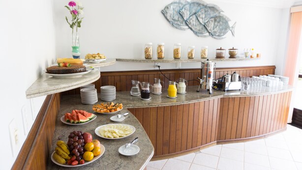 Un buffet de petit-déjeuner proposant une variété d'aliments, notamment des fruits, des viennoiseries et des boissons.