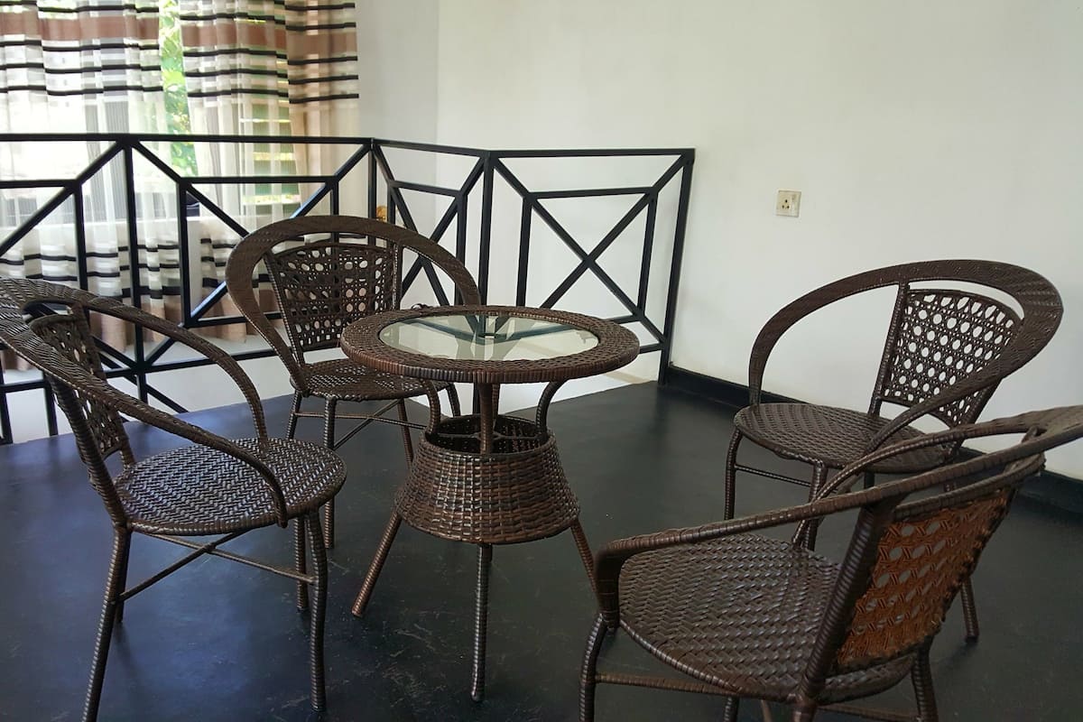 A dining area with a dark table and wicker chairs.