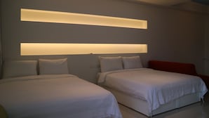 A modern hotel room with two beds, a red accent wall, and recessed ceiling lighting. - Manman B&B (Sanxing)