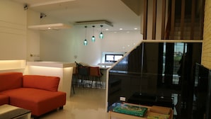 A modern living room with a red sofa, a wooden coffee table, and a glass partition. - Manman B&B (Sanxing)