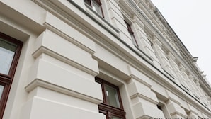 A building with classical architecture, featuring symmetrical window designs and decorative moldings. - City Park Apartment 23 (Leipzig)