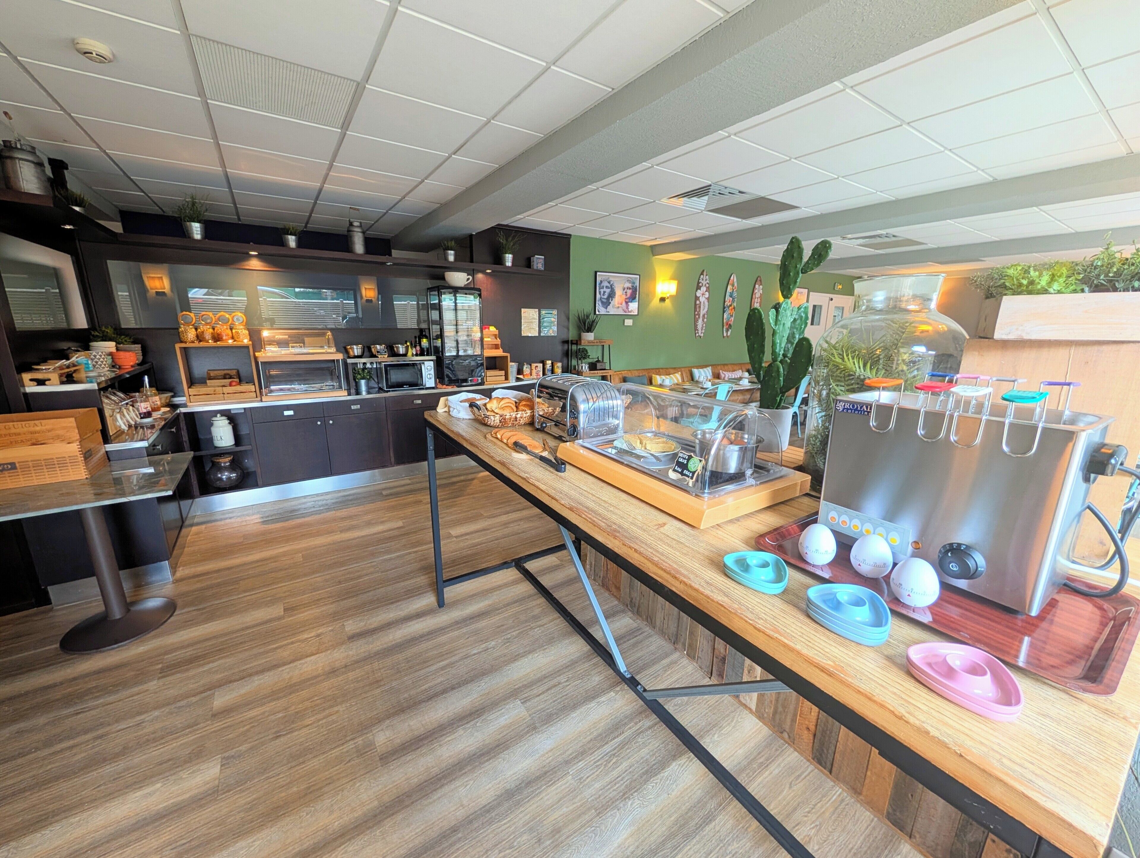 Un café avec un comptoir en bois, une machine à café et un présentoir de pâtisseries.