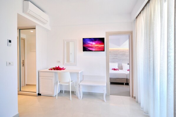 A modern hotel room with a desk, chair, and a bed. - Apollon Windmill Hotel (Kos)