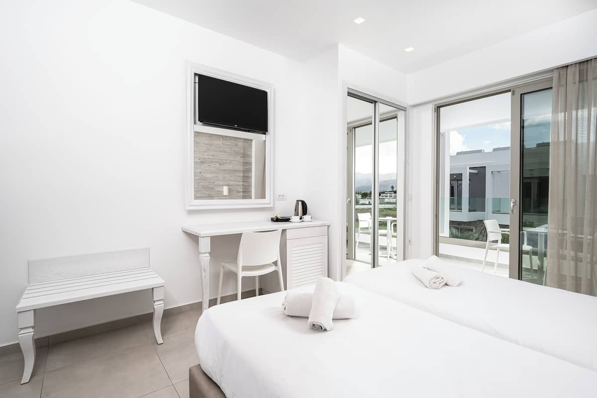 Habitación triple Deluxe, vistas al jardín | 1 dormitorio, sistema de insonorización, ropa de cama