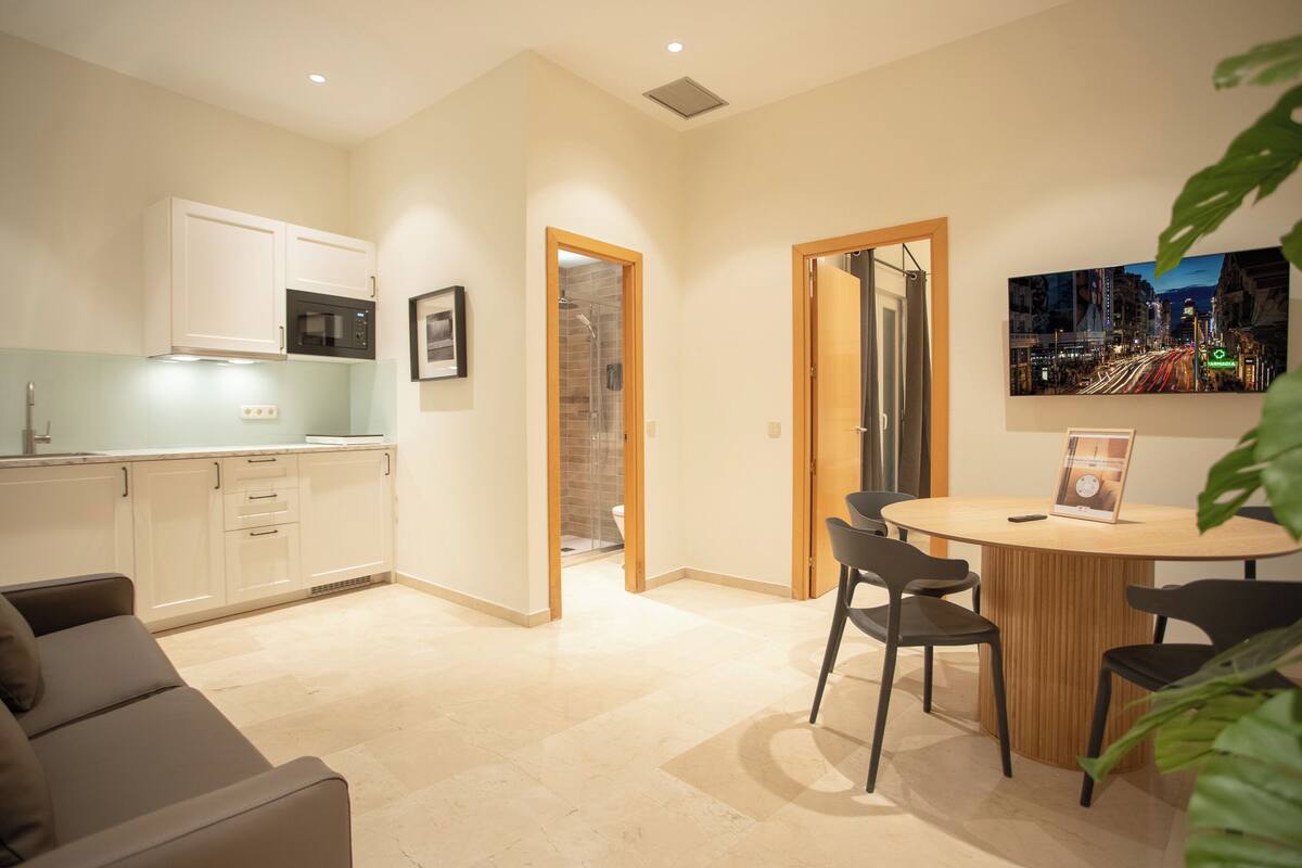 A modern apartment with a kitchen, dining area, and a living room.