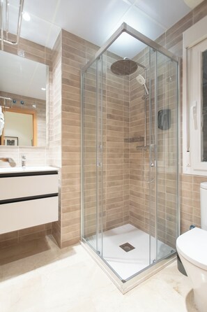 Apartamento família | Banheiro | Chuveiro, secador de cabelo, toalhas de banho, papel higiênico