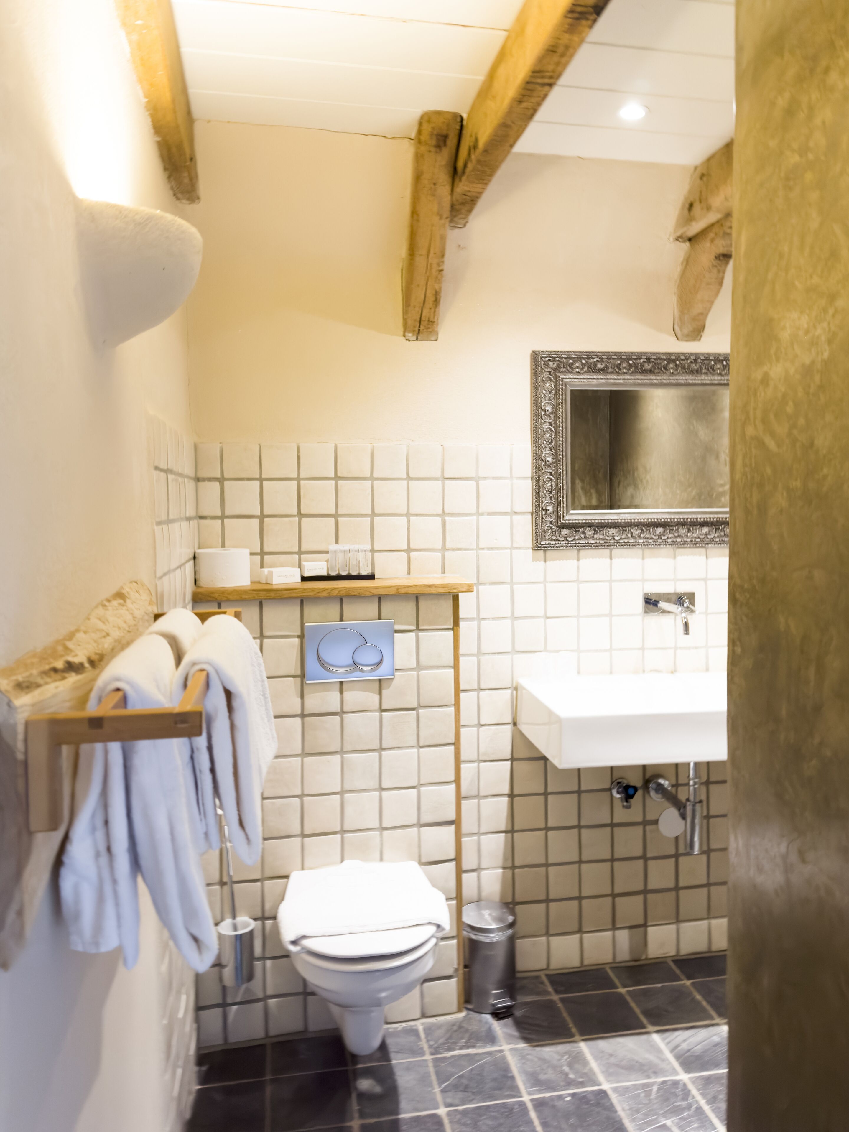 A bathroom with a toilet, sink, and towel rack.