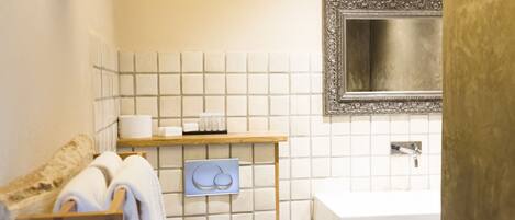 A bathroom with a toilet, sink, and towel rack.