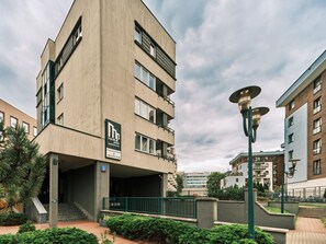 A modern apartment building with a flat facade, multiple balconies, and a sign indicating it is a residential complex. - Media Park (Warsaw)