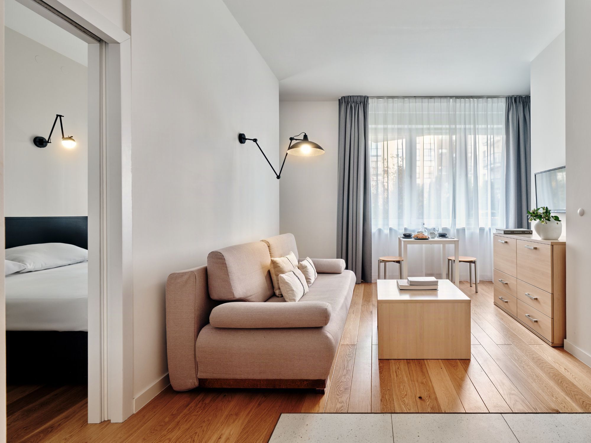 Ein modernes Wohnzimmer mit einer Couch, einem Couchtisch und einem Essbereich mit Tisch und Stühlen.