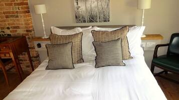 Una habitación de hotel con una cama, dos lámparas de noche, una silla y un cuadro en la pared.