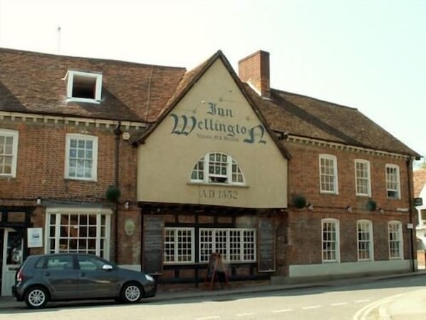 A traditional pub named 'The Sun Wellington' with a classic brick facade and a large arched window.