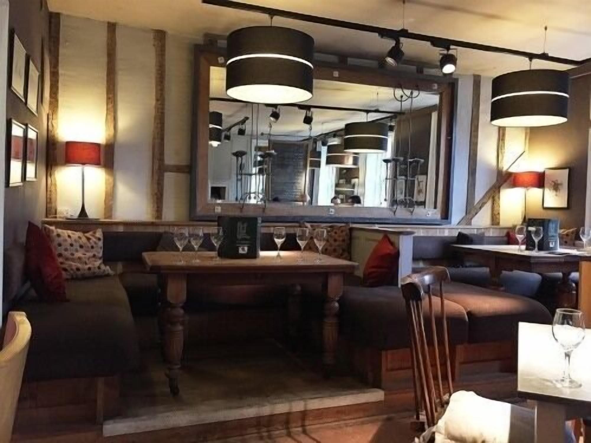 Un restaurante acogedor con mesa de madera, asientos acolchados e iluminación colgante.