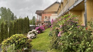 A hotel with a sign reading "Spice Hut" on the exterior, surrounded by well-maintained gardens and a variety of flowering plants. - Holiday House Motel (Ladysmith)