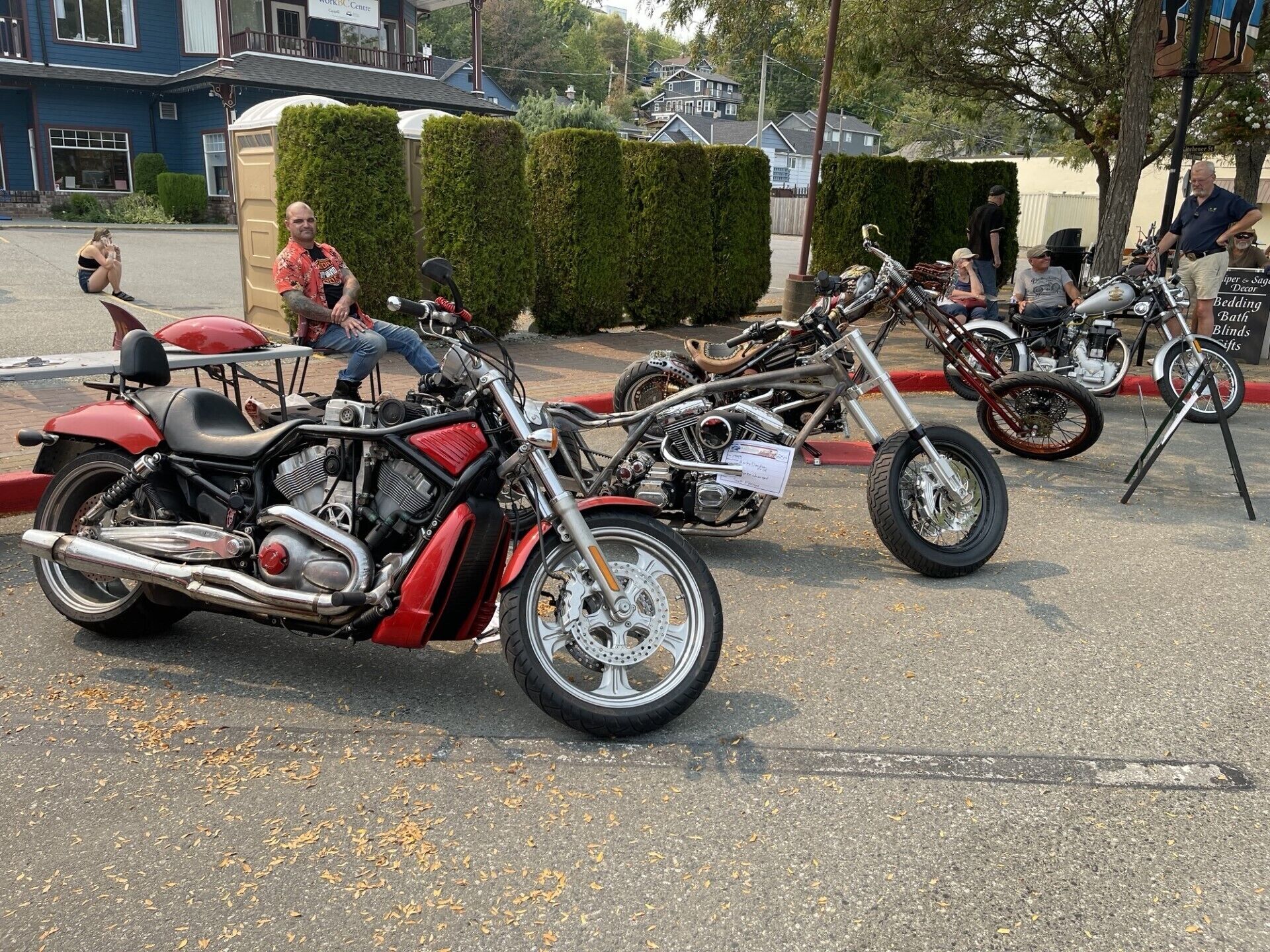 A row of custom motorcycles parked in a driveway.