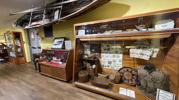 A museum exhibit with historical artifacts, including pottery and textiles, displayed in glass cases.