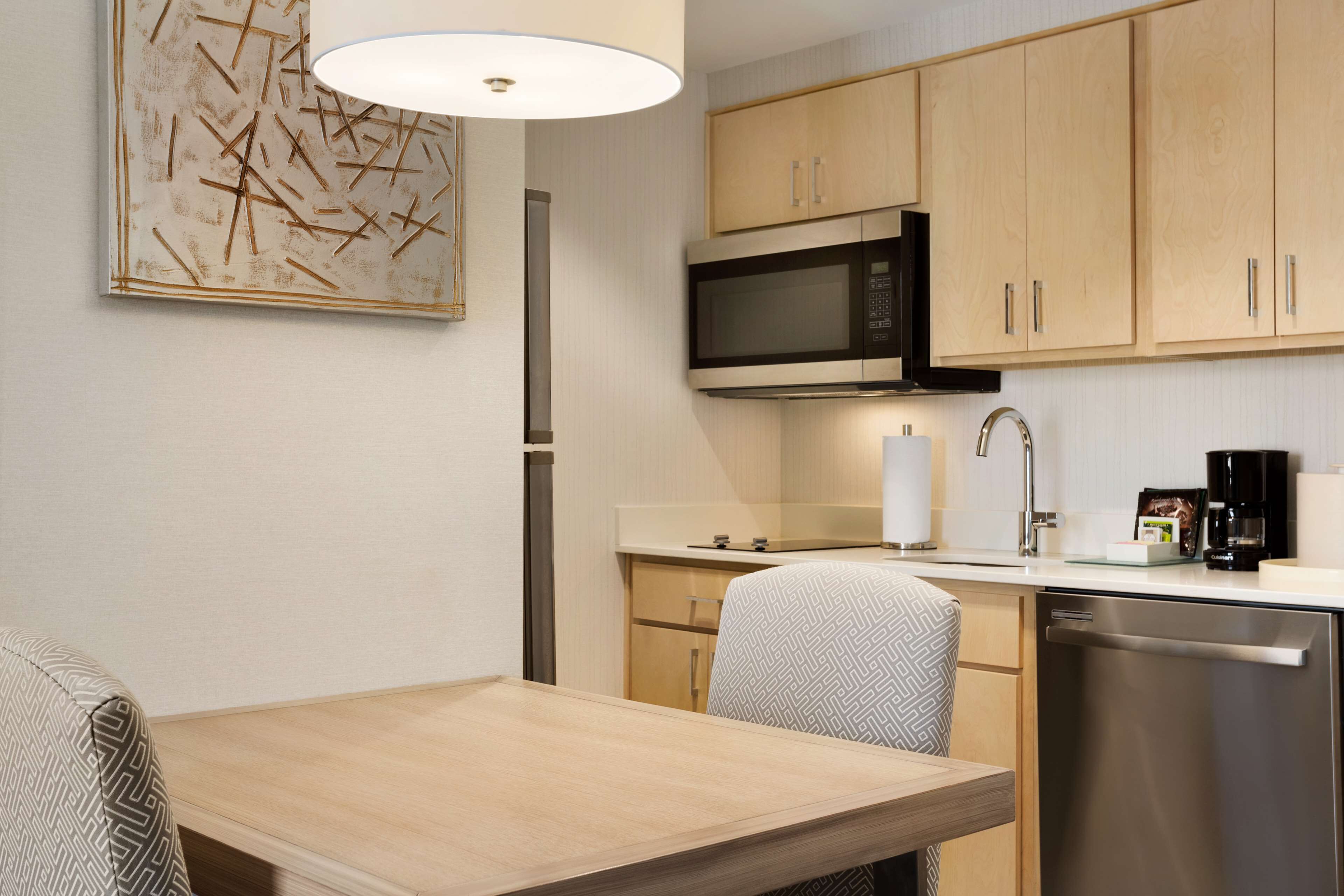 Una cocina compacta equipada con microondas, cafetera y lavavajillas.