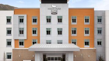 Un moderno edificio de hotel con un cartel que dice "Homewood Suites Hilton".
