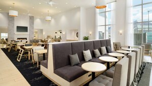A modern hotel lobby with a seating area, tables, and a large window offering a view. - Homewood Suites By Hilton Salt Lake City Draper (Draper)