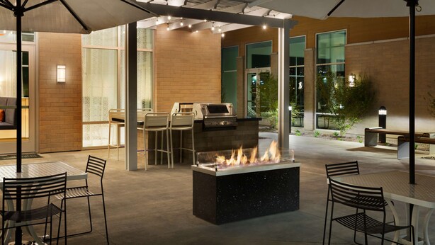 An outdoor patio area with a fire feature, seating, and a grill. - Homewood Suites By Hilton Salt Lake City Draper (Draper)