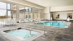 A modern indoor pool area with clear glass walls, a hot tub, and a separate swimming pool. - Homewood Suites By Hilton Salt Lake City Draper (Draper)
