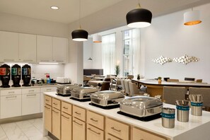 A modern kitchen with white cabinets, stainless steel appliances, and a breakfast bar. There are various kitchen utensils and appliances visible. - Homewood Suites By Hilton Salt Lake City Draper (Draper)