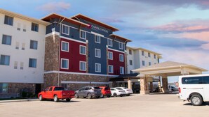 A multi-story hotel with a modern design, featuring a mix of stone and painted exteriors. - Candlewood Suites Fargo South- Medical Center by IHG (Fargo)