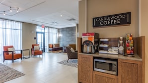 A modern lobby with a coffee station, seating area, and an exit sign. - Candlewood Suites Fargo South- Medical Center by IHG (Fargo)
