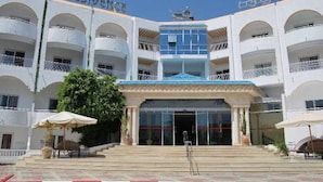 A multi-story building with a central entrance, balconies, and a sign reading "GOLF RESIDENCE".