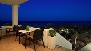 A terrace with a table and chairs, overlooking a coastal landscape at dusk. - Argo (Karpathos)