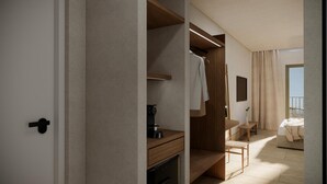 A modern hotel room with a walk-in closet, a wooden vanity, a small table, and a view of the balcony. - Argo (Karpathos)